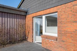 a brick building with a sliding glass door at Fewo Nissen Dagebüll in Dagebüll
