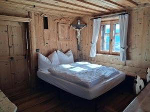 a bed in a wooden room with a window at Peintnerhof Percha in Perca