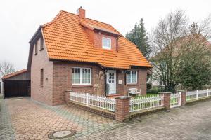 a brick house with an orange roof and a fence at Cosy Apartment In Soltau in Soltau