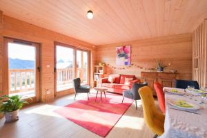 a living room with a couch and a table and chairs at Appartement dans le Chalet l'Albert in Manigod