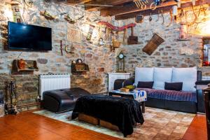 a living room with a couch and a tv on a stone wall at La Plazuela I in Pereña