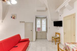a living room with a red couch and a tv at Dimore degli innamorati in Presicce