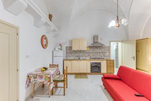 a living room with a red couch and a table at Dimore degli innamorati in Presicce