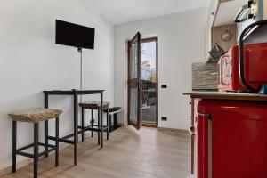 a kitchen with two stools and a table with a television at Casa Zoe in Arco