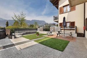 a backyard with a patio with a lawn at Casa Zoe in Arco