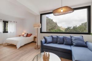 a living room with a blue couch and a window at Finca Los Tilos Moya in Moya