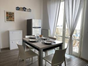 a dining room with a table and chairs and a window at A7 Trilocale Fronte Mare in Marina di Grosseto