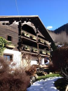 a wooden house with flowers on the side of it at Chalet authentique luxe piscine in Les Contamines-Montjoie