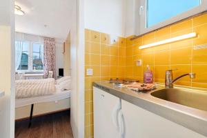 a bathroom with a sink and a yellow wall at Haus Margarete Christel Winkelmann in Cuxhaven +56 photos