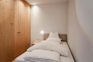 a bedroom with a bed with white sheets and pillows at Valentinerhof Apt Air in San Michele