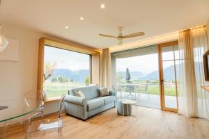 a living room with a couch and a large window at Valentinerhof Apt Air in San Michele