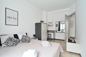 a bedroom with a white bed with pillows and a kitchen at Jerzu Centro in Jerzu +9 photos