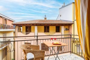 a balcony with a table and chairs and a yellow building at Jerzu Centro in Jerzu