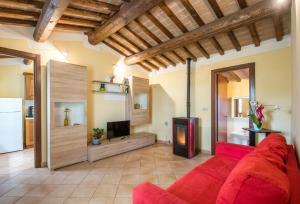 a living room with a red couch and a tv at Faetino - Pavone in Colle di Val d'Elsa