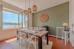 a dining room with a table and chairs and a clock at Évasion marine face à la mer in Plouézocʼh
