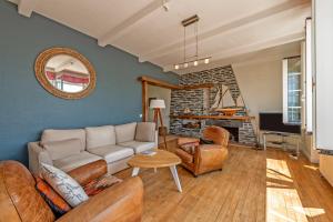a living room with a couch and a fireplace at Évasion marine face à la mer in Plouézocʼh