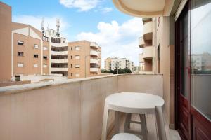 a white stool sitting on a balcony with a table at A O - La Source in Peniche