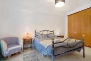 a bedroom with a bed and a chair at A O - La Source in Peniche