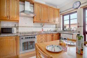 a kitchen with wooden cabinets and a wooden table at A O - La Source in Peniche