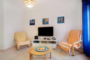 a living room with two chairs and a flat screen tv at A O - La Source in Peniche