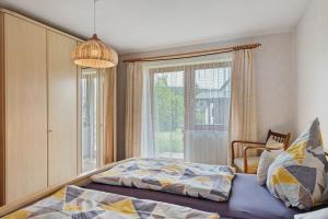 a bedroom with a bed and a large window at Haus Marianne Dörflinger in Schluchsee