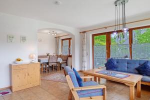 a living room with a blue couch and a table at Haus Marianne Dörflinger in Schluchsee