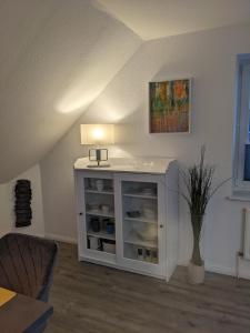 a white cabinet in the corner of a room at Ferienwohnung Auszeit in Niebüll