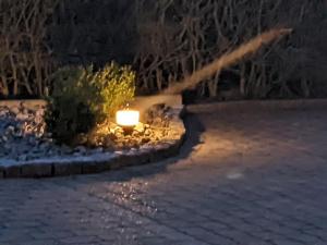 a light in a garden in the snow at night at Ferienwohnung Auszeit in Niebüll