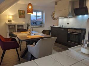a kitchen and dining room with a table and chairs at Ferienwohnung Auszeit in Niebüll +4 photos