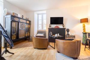 a living room with two chairs and a tv at L'Eclose Chambre Kergoz in Le Guilvinec