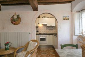 a kitchen with an archway and a table and chairs at Casina nel Borgo Antico in Bibbona