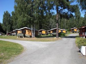 une route en gravier menant à un groupe de cabines dans l'établissement Steinvik Camping, à Moelv