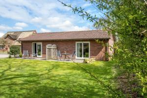 a brick house with a lawn in front of it at Apartment Eulenhof 2 in Bordelum