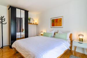 a bedroom with a large white bed and a desk at Stella Lilia in Radolfzell am Bodensee