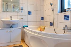 a bathroom with a bath tub and a sink at Stella Lilia in Radolfzell am Bodensee +16 photos