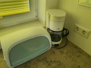 a tv sitting in a kitchen with a coffee maker at Obst- und Ferienhof Schäfler in Hattnau