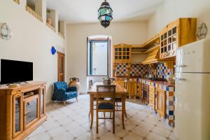 a kitchen with a table and a refrigerator at Dimora Cariddi Otranto in Otranto