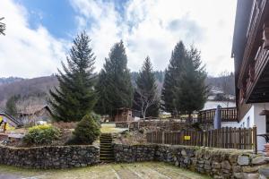 a yard with a stone retaining wall and trees at Haus Maria in Todtnau +67 photos