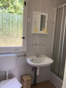 a bathroom with a sink and a toilet and a window at Bunte Ferienhaussiedlung in Rheinsberg +37 photos