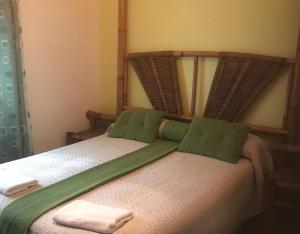 a bed with two green pillows on top of it at Chalet Del Sol in Puerto Lumbreras +30 photos