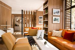 a living room with an orange couch and chairs at Hôtel Eiffel Turenne in Paris