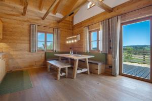 ein Esszimmer mit einem Tisch und einem großen Fenster in der Unterkunft Bergchalet 1 in Freyung
