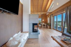 ein Wohnzimmer mit Kamin und Fernseher in der Unterkunft Bergchalet 1 in Freyung