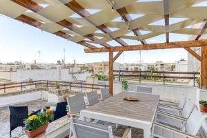 a patio with a wooden table and chairs on a roof at Dimore degli innamorati in Presicce