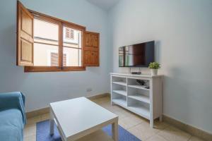 a living room with a couch and a tv at Maca Green, Adosado Centro Campanet in Campanet