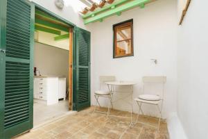a room with green doors and a table and two stools at Maca Green, Adosado Centro Campanet in Campanet +15 photos