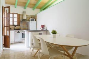 a kitchen with a white table and chairs at Maca Green, Adosado Centro Campanet in Campanet