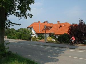 a person riding a bike in front of a house at Ferienwohnung Evi Opp - Harmonie in Brodersdorf