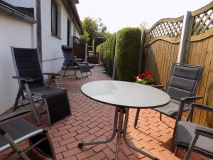a patio with a table and chairs on a brick patio at Ferienwohnung Evi Opp - Harmonie in Brodersdorf +8 photos