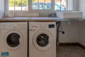 a kitchen with two washing machines and a counter at Charmant Cottage - Saint-Junien in Saint-Junien